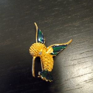 Adorable gold tone and enamel hummingbird brooch.